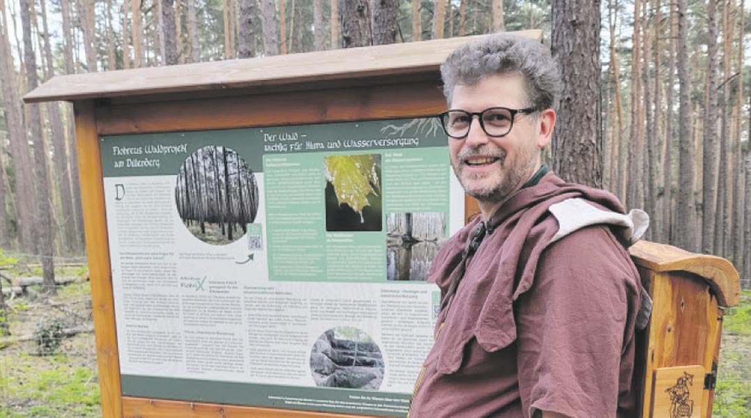 Dillenbergflüsterer Frank Flohr im Wald vor einer Schautafel