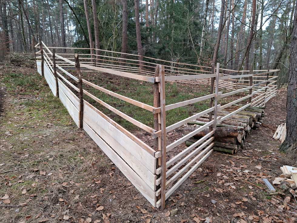 Femel, eine kleine Lichtung mit einem Holzzaun eingefasst.