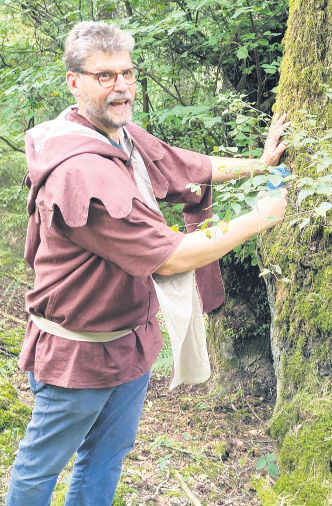 Frank Dillenberger steht neben einem Baum und misst die Temperatur.